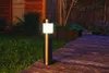 A solar garden light illuminates a wooden deck and surrounding garden at dusk. Podgląd zdjęcia produktu