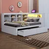 A white daybed with storage drawers and shelves, set up in a bedroom with pink walls and a patterned rug. Produktbild-Vorschau