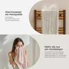 A split image showing a towel warmer with steam and a woman drying her face with a towel. Produktbild-Vorschau