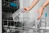 A person is placing clear plastic containers into a dishwasher. Náhľad obrázku produktu