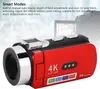 A red camcorder is shown in front of a blurred background with a screen displaying people. Podgląd zdjęcia produktu