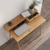 A top-down view of a wooden desk with a laptop, a smart speaker, a plant, and a drawer with items inside. Produktbild-Vorschau