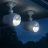 Two white outdoor motion-sensor lights mounted under a wooden overhang during a rain shower. Produktbild-Vorschau
