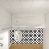 A top-down view of a bathtub with a patterned tile backsplash and a floral rug. Produktbild-Vorschau