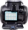 A close-up view of the back of a black vacuum cleaner, showing an open compartment with a blue filter and the power cord plug. Produktbild-Vorschau