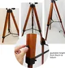Collage of images showing a wooden tripod floor lamp from different angles, with a close-up of a hand adjusting a knob. Anteprima dell’immagine prodotto