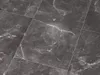 A close-up view of dark gray marble tiles with white veining. Produktbild-Vorschau