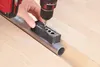 A person is using a drill with a jig to drill a hole in a metal pipe. Anteprima dell’immagine prodotto