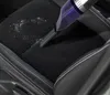 A handheld vacuum cleaner is being used to clean debris from a car seat. Produktbild-Vorschau