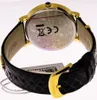 The back of a gold-toned watch with a black leather strap. Produktbild-Vorschau