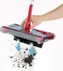 A hand is shown pressing down on a red and gray cordless sweeper, demonstrating how it picks up dirt. Produktbild-Vorschau