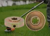 Two metal adapters for a string trimmer are shown on a grassy lawn, with the shaft of the trimmer visible in the background. Anteprima dell’immagine prodotto