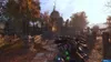 A first-person perspective of a video game scene, showing a weapon in the foreground and a post-apocalyptic environment in the background. Produktbild-Vorschau