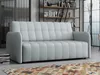 A light gray sofa is shown in a modern living room setting with bookshelves in the background and a rug on the floor. Náhled obrázku produktu