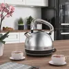 A modern kitchen counter with a kettle, cups of tea, and plants. Podgląd zdjęcia produktu
