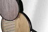 A close-up view of a decorative wall mirror with wooden elements and a black frame. Produktbild-Vorschau
