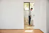 A man is standing on a scale in a bathroom. Produktbild-Vorschau