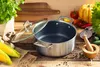 A cooking pot with a glass lid is placed on a wooden table, surrounded by fresh vegetables and herbs. Podgląd zdjęcia produktu