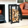 A black metal firewood rack filled with logs is placed next to a fireplace, with an orange armchair in the background. Anteprima dell’immagine prodotto