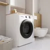 A modern laundry room or bathroom with a washing machine, toilet, and storage. Anteprima dell’immagine prodotto