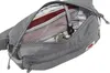 Close-up view of an open gray fanny pack, showing its interior compartments and contents. Voir les images du produit