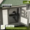 A close-up view of a wooden chicken coop with an open door, showing the interior and a green roof. Produktbild-Vorschau