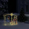 A lighted nativity scene decoration is displayed outdoors at night, with a Christmas tree in the background. Anteprima dell’immagine prodotto