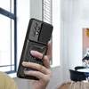 A hand holding a black phone case with a ring stand and camera cover. Náhľad obrázku produktu