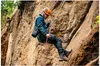 A person rappelling down a rock face. Produktbild-Vorschau