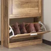 A close-up view of a wooden shoe cabinet with two flip-out drawers containing shoes. Voir les images du produit