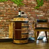 A wine barrel cabinet with a bottle of wine and a glass of wine on top, placed against a brick wall with greenery. Náhled obrázku produktu