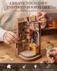 A person's hands assembling a miniature bookstore model. Náhled obrázku produktu