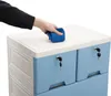 A hand is wiping the top of a blue and white plastic chest of drawers. Voir les images du produit