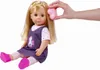 A doll is sitting down with a hand brushing its hair. Anteprima dell’immagine prodotto