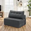 A gray foldable sofa bed is shown in a living room setting with a window and curtains in the background. Náhled obrázku produktu