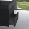 A close-up view of a black vanity cabinet with one drawer pulled out, in front of a large window looking out onto a garden. Anteprima dell’immagine prodotto