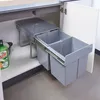 A built-in trash can with two compartments is pulled out from under a kitchen counter. Anteprima dell’immagine prodotto