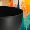 A close-up of a black planter against a colorful, abstract background. Produktbild-Vorschau