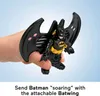 A child's hand holding a Batman action figure with attachable wings. Podgląd zdjęcia produktu