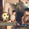 A father and son are playing with toy cars inside a tent, with a soccer ball-shaped night light visible. Produktbild-Vorschau