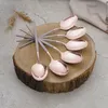 A set of rose gold spoons with gray handles arranged on a wooden slice. Náhľad obrázku produktu