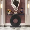 A modern console table with a decorative circular base, displayed in an elegant entryway with wall art and decorative objects. Náhľad obrázku produktu