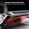 A red and black phone case with a ring stand is shown in a close-up shot, with a laptop and headphones in the background. Produktbild-Vorschau