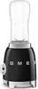 A black Smeg blender with a clear blending cup and silver accents, shown from the front. Voir les images du produit