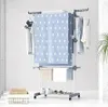 A multi-level cloth drying stand with clothes and towels on it, placed indoors. Produktbild-Vorschau