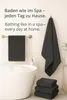 A bathroom scene with towels and a bathtub. Produktbild-Vorschau