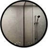 A round mirror with a black frame reflecting a modern bathroom with tiled walls and a shower head. Produktbild-Vorschau