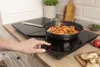A hand is shown adjusting a portable induction cooktop with a pan of shrimp cooking on it. Anteprima dell’immagine prodotto