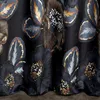 A close-up view of a dark fabric with a floral and leaf pattern. Produktbild-Vorschau