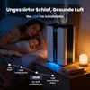 A woman and a baby sleeping in a bed, with an air purifier on a nightstand next to them. Náhled obrázku produktu
